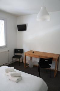 um quarto com uma secretária e uma mesa com 2 cadeiras em Le Bistroquet em Lusignan