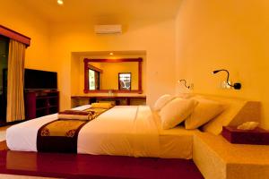 a bedroom with a large bed and a mirror at Taman Senang in Gili Islands