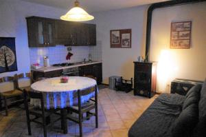 a living room with a table and a kitchen at Fattoria La Guedrara in Sestola