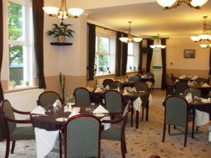a dining room with tables and chairs and windows at Lauriston Hotel in Weston-super-Mare