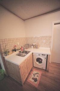 a kitchen with a sink and a washing machine at Wansangolgh Guest House in Jeonju