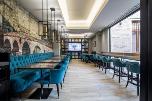 rzędu stołów i krzeseł w restauracji z niebieskimi miejscami w obiekcie Hotel Milano & SPA***S w Weronie