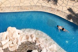 an overhead view of a man swimming in a pool at Crusoe Cabins Casobe in Calatagan