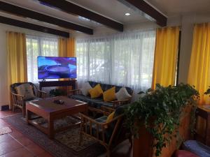 Jabbitos Baguio Transient House 2 في باغيو: غرفة معيشة مع أريكة وتلفزيون