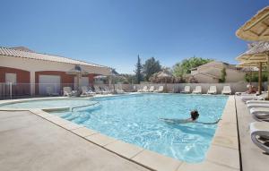 a person in a swimming pool at a hotel at Résidence Odalys Le Mas des Flamants in Aigues-Mortes