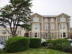 a large brick house with cars parked in front of it at Lauriston Hotel in Weston-super-Mare