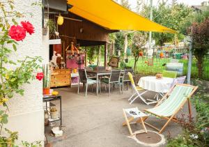 eine Terrasse mit einem Tisch und Stühlen sowie einem gelben Regenschirm in der Unterkunft Bed&Breakfast Pinocchio in Seuzach