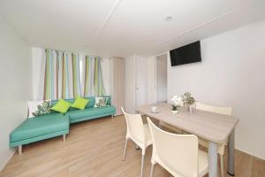 a living room with a couch and a table with chairs at Mobile homes Kamp Maslina, Biograd na Moru in Biograd na Moru