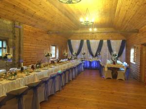 un salón de banquetes con mesas y sillas en un granero en Guest House Zirga Smaids, en Kušneri