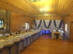 a banquet hall with tables and chairs in a barn at Guest House Zirga Smaids in Kušneri