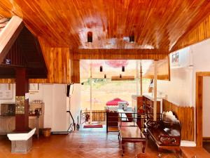 a living room with a wooden ceiling and a table at Merry Riverside Hotel in Luang Prabang