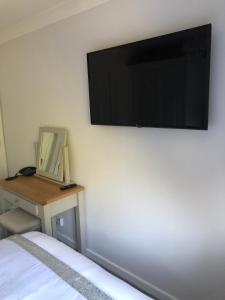 
a television and a bed in a room at Old Hunters Lodge in Whipsnade
