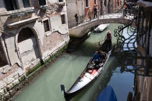um grupo de pessoas a andar de gôndola por um canal em Ca' Via della Seta em Veneza