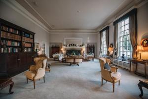 een grote woonkamer met stoelen en een open haard bij Hemswell Court in Hemswell