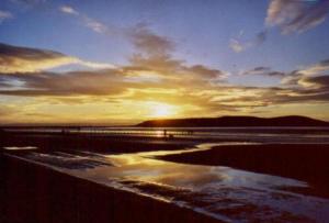 a sunset over a beach with the sun setting at Lauriston Hotel in Weston-super-Mare