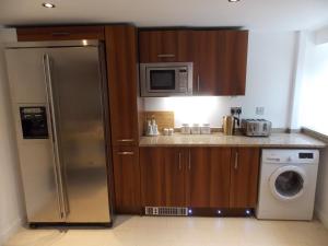 a kitchen with a stainless steel refrigerator and a microwave at Fryers Cottage in Richmond