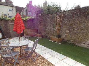 a patio with a table and chairs and an umbrella at Fryers Cottage in Richmond