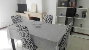 a dining room table with four chairs and a fireplace at Tavira sweet home in Tavira