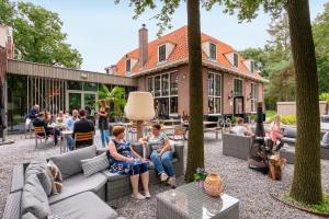 a group of people sitting on couches in a courtyard at Stayokay Hostel Soest in Soest