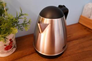 a metal kettle on a table next to a plant at Nang-an Inn Resort in Surat Thani