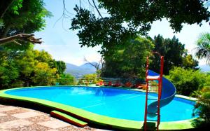 una piscina con un tobogán junto a un complejo en Hotel Piedras de Sol Solaris Morelos, en Tlaltizapán