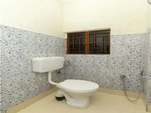 a bathroom with a toilet and a window at Hotel Travellers INN in Shillong