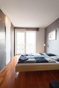 ブダペストにあるLoft Studio Dandár With Free Parkingのベッドルーム(大型ベッド1台、大きな窓付)