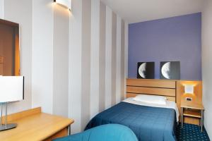 a bedroom with a blue bed and striped walls at Garda Hotel in Montichiari