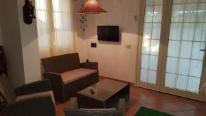 瑪勞薩的住宿－Casa Vacanze Marausa Birgi KITE，客厅配有椅子、桌子和电视
