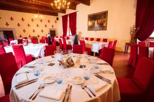 a dining room with white tables and red chairs at Château Des Ducs De Joyeuse in Couiza