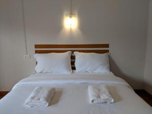 uma cama com duas toalhas em cima em Maruay em Surat Thani