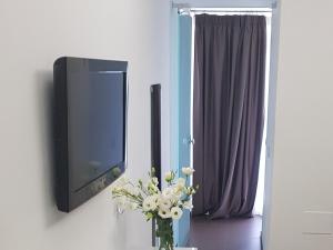 un vase de fleurs devant une télé dans l'établissement B&B Copacabana Colors, à Margherita di Savoia