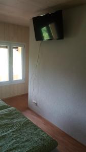 1 dormitorio con TV colgada en la pared en b&b krättli, en Eggiwil