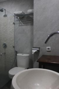 a bathroom with a toilet and a sink and a tub at Onih Hotel in Bogor