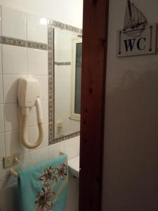 a bathroom with a towel and a sink and a mirror at Casa Vacanze Marausa Birgi KITE in Marausa