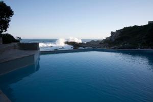 a pool of water with waves in the ocean at Bayview 303 in Hermanus