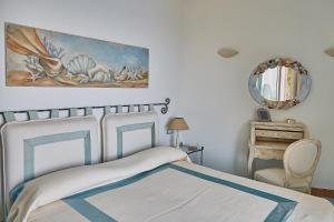 a bedroom with a bed and a painting on the wall at Residence Leonardo in Capri