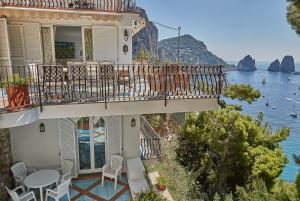een huis met een balkon met uitzicht op het water bij Residence Leonardo in Capri