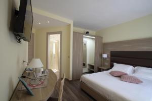 - une chambre avec un lit et une télévision murale dans l'établissement "Il Viottolo" Rooms and Breakfast, à Roccaraso