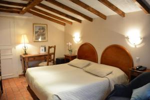 A bed or beds in a room at Logis Le Clos Deauville Saint Gatien