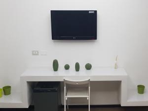 - un bureau blanc avec une télévision murale dans l'établissement B&B Copacabana Colors, à Margherita di Savoia 13 autres photos