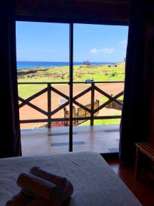 a bedroom with a view of the beach from a window at Cabañas Anavai Rapa Nui in Hanga Roa