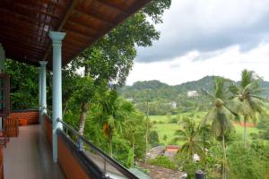 a balcony of a house with a view of a field at Rathna Gems Halt in Ratnapura
