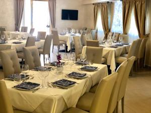 ein Esszimmer mit Tischen und Stühlen sowie weißen Tischdecken in der Unterkunft Hotel Riviera Palace in Porto Empedocle