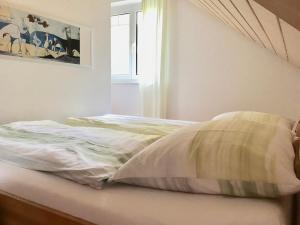 niepościelone łóżko w sypialni z oknem w obiekcie Apartment Johanna w mieście Radolfzell am Bodensee