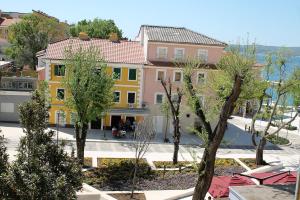 a view of a building with trees in front of it at Apartmani Vila Angelina in Selce