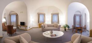 ein Wohnzimmer mit weißen Möbeln und Bogenfenstern in der Unterkunft Hotel Cavour Et Des Officiers in Bard