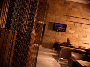 a dining room with a stone wall and a television at Harbour Grand Hong Kong in Hong Kong