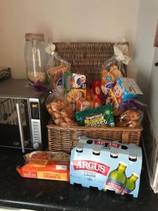 una cesta de comida y aperitivos junto a un microondas en Central city 1 bed apartment, en Bath