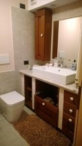 bagno con lavandino, servizi igienici e specchio di BORMIO Centro storico a Bormio